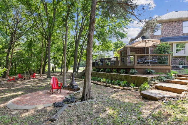 view of yard featuring a deck and a fire pit