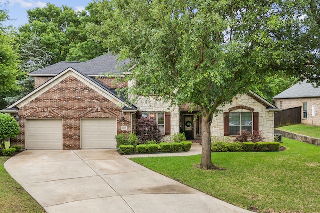 view of property hidden behind natural elements with an attached garage, a front lawn, stone siding, brick siding, and concrete driveway