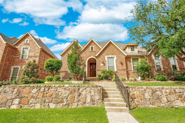 tudor-style house featuring brick siding