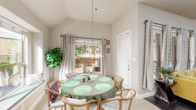 dining room with visible vents, lofted ceiling, baseboards, light tile patterned floors, and a notable chandelier
