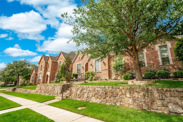 view of front of house with brick siding, a residential view, and a front yard