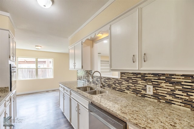 kitchen featuring white cabinets, appliances with stainless steel finishes, a sink, light wood-style floors, and tasteful backsplash
