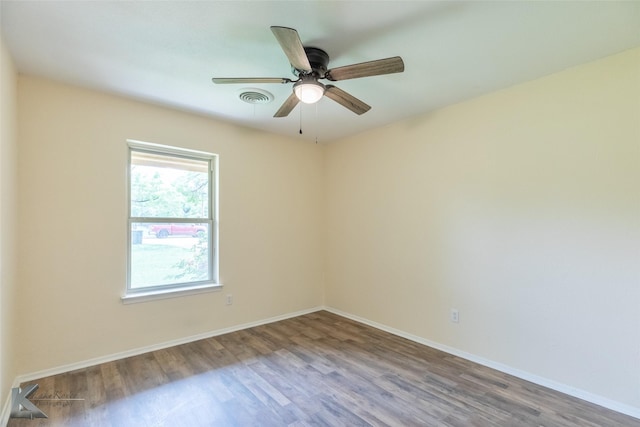 spare room with baseboards, ceiling fan, wood finished floors, and visible vents