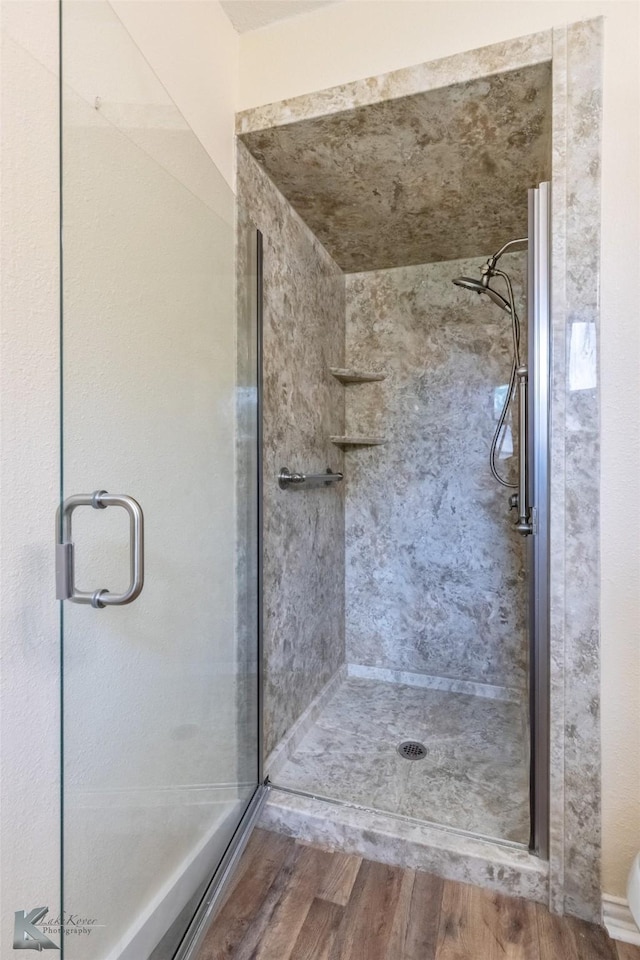 full bath featuring a stall shower and wood finished floors