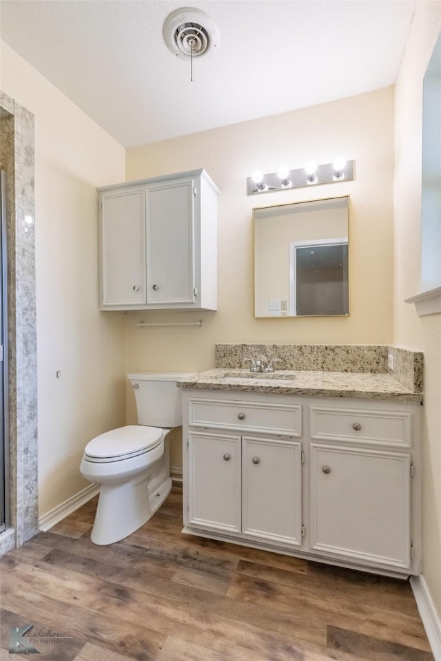 full bathroom with visible vents, a shower stall, wood finished floors, vanity, and toilet
