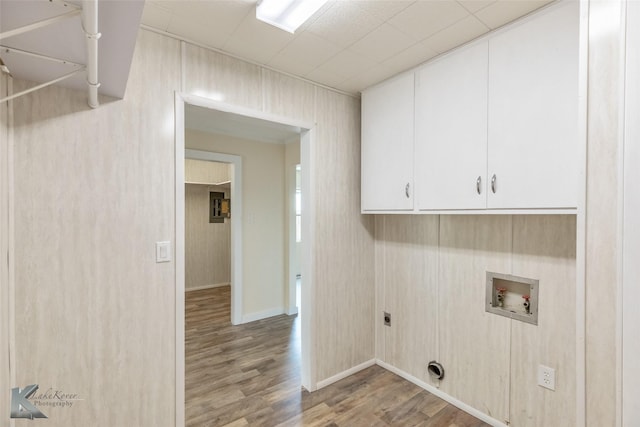 laundry area featuring wood finished floors, baseboards, hookup for a washing machine, cabinet space, and hookup for an electric dryer