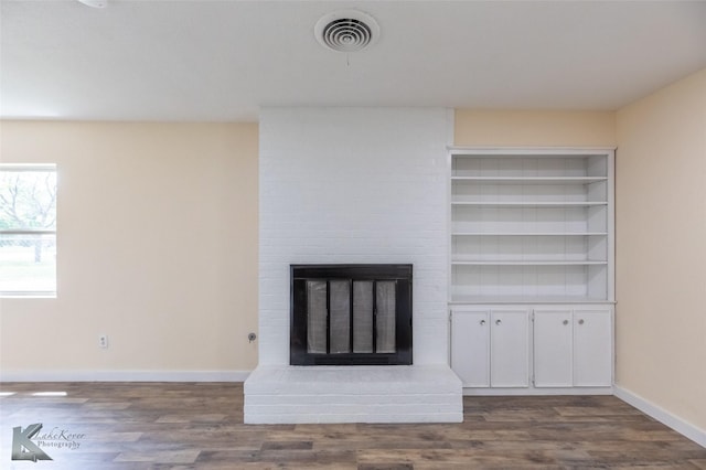 details featuring baseboards, a fireplace, wood finished floors, and visible vents