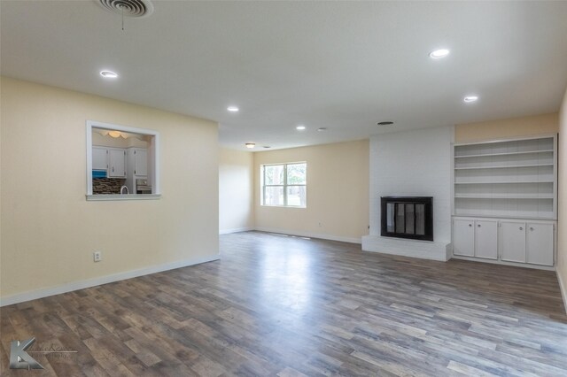 unfurnished living room with recessed lighting, visible vents, wood finished floors, and a fireplace