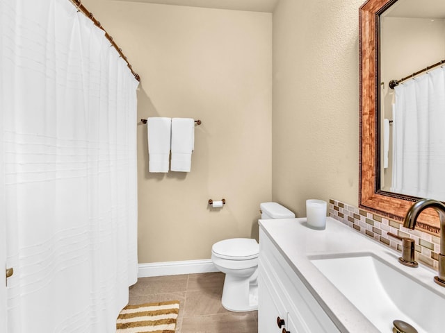 full bathroom featuring vanity, toilet, tile patterned floors, baseboards, and decorative backsplash