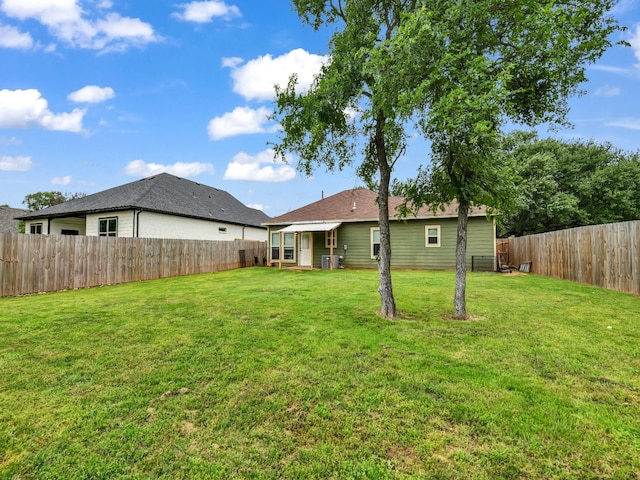 view of yard featuring a fenced backyard and central AC
