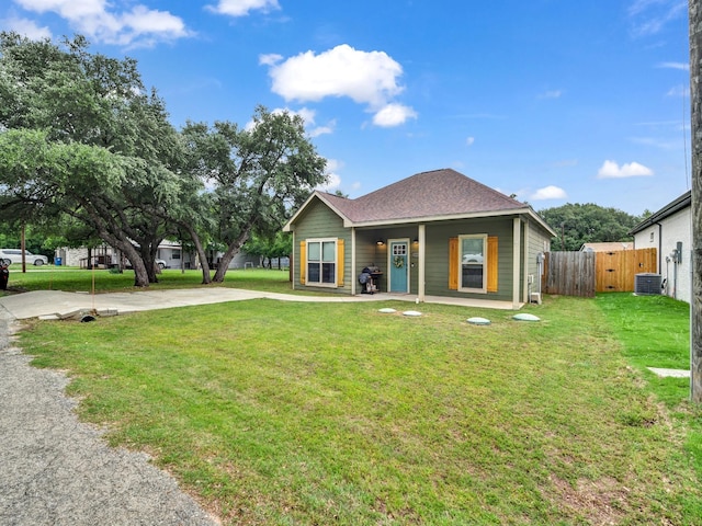 bungalow-style house featuring covered porch, a front yard, central AC, fence, and a shingled roof