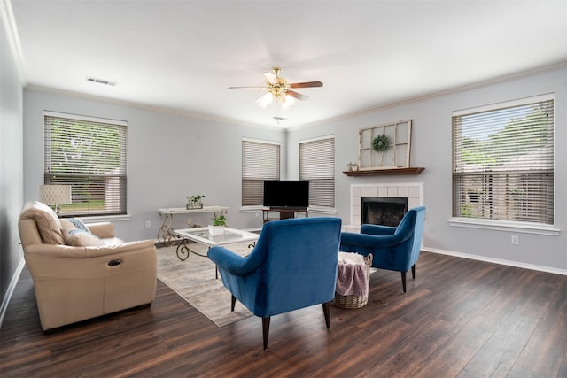 living area featuring visible vents, crown molding, wood finished floors, a healthy amount of sunlight, and a ceiling fan