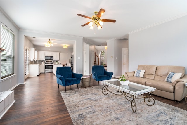 living area featuring a ceiling fan, plenty of natural light, and stairway