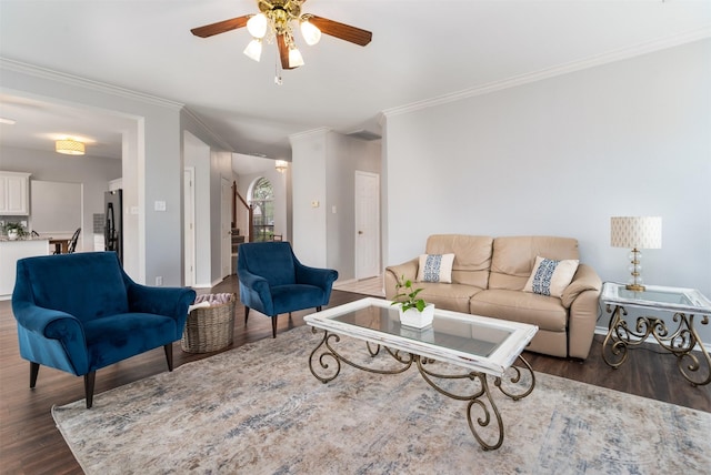 living area with stairway, ornamental molding, a ceiling fan, and wood finished floors