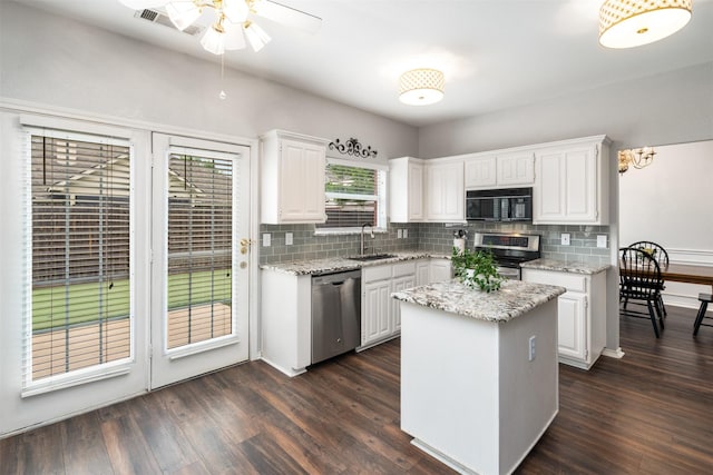 kitchen with ceiling fan, white cabinets, a sink, backsplash, and stainless steel appliances