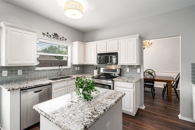 kitchen featuring dark wood-style flooring, white cabinets, tasteful backsplash, a sink, and appliances with stainless steel finishes