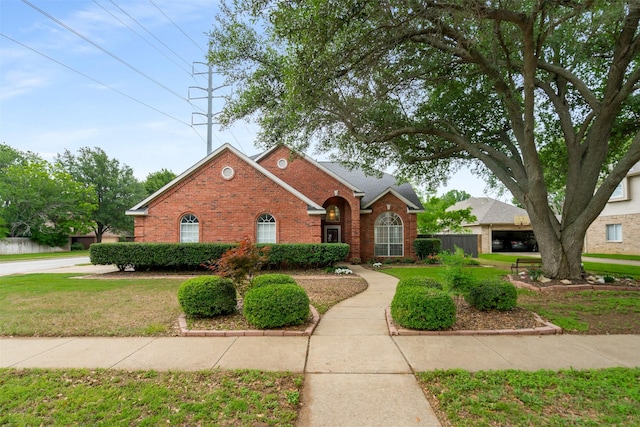 view of front of house featuring fence, a front lawn, and brick siding
