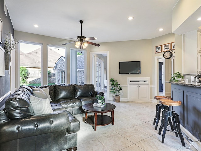 living area featuring plenty of natural light, a ceiling fan, recessed lighting, light tile patterned floors, and baseboards