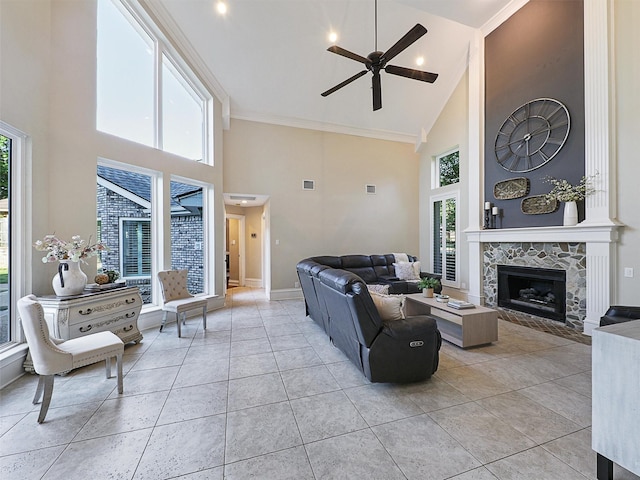 living area featuring high vaulted ceiling, ceiling fan, healthy amount of natural light, a fireplace, and baseboards