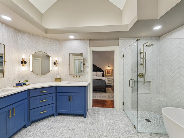 bathroom with lofted ceiling, ensuite bathroom, a stall shower, double vanity, and a freestanding bath