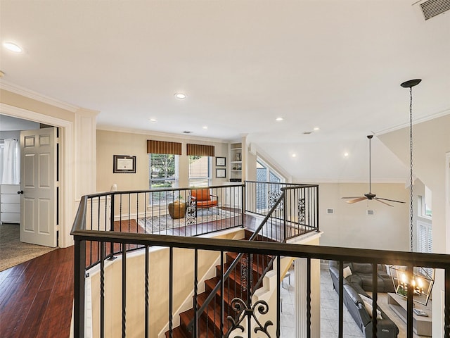 hall featuring ornamental molding, an upstairs landing, wood finished floors, and recessed lighting