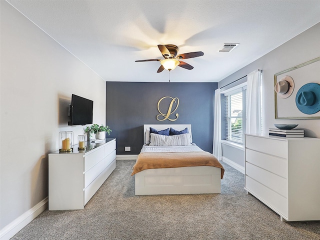 carpeted bedroom featuring baseboards and a ceiling fan