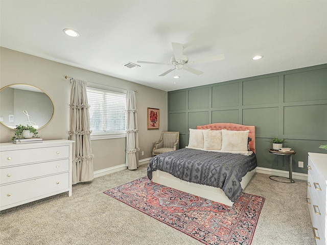 bedroom featuring a decorative wall, recessed lighting, light carpet, a ceiling fan, and baseboards