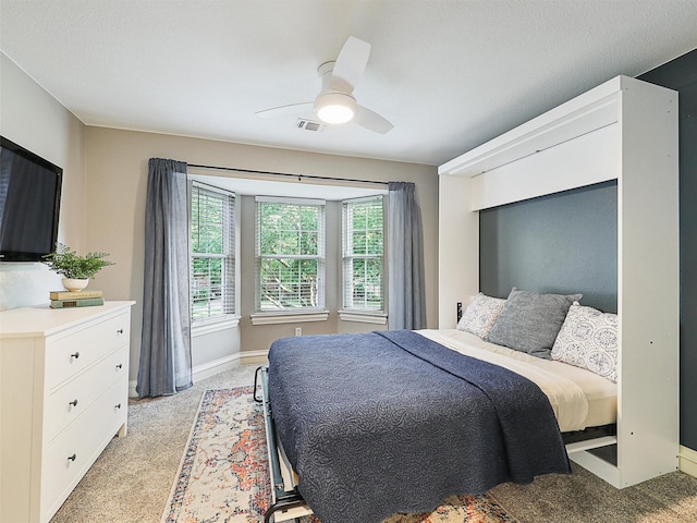 bedroom featuring light carpet, baseboards, and a ceiling fan