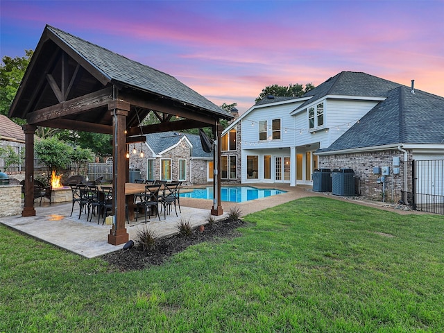 view of swimming pool featuring a gazebo, central AC unit, an outdoor fire pit, and a patio area
