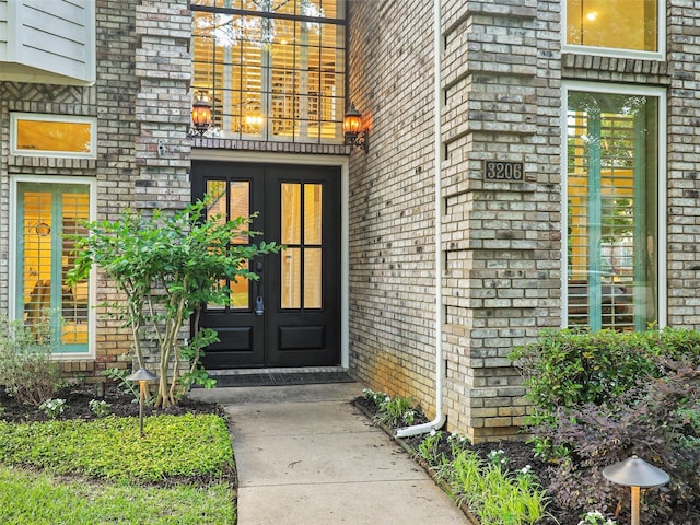 entrance to property featuring french doors and brick siding