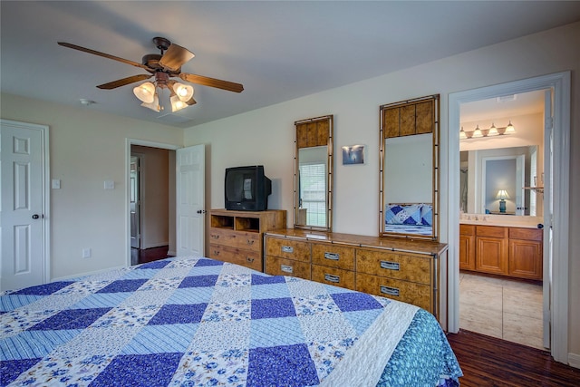 bedroom with dark wood-type flooring, connected bathroom, and ceiling fan