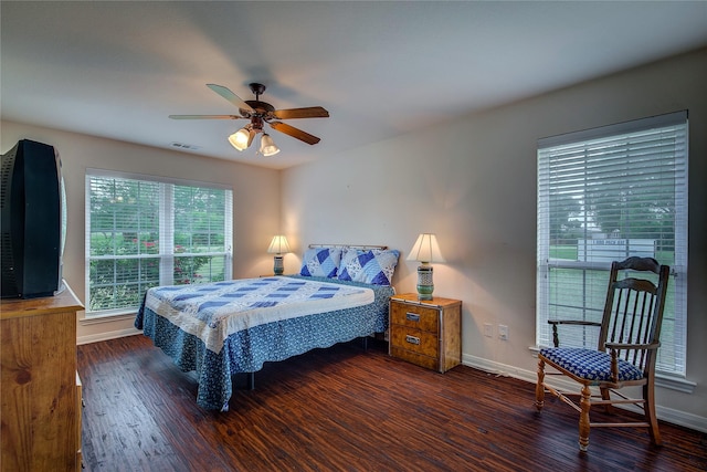 bedroom with baseboards, ceiling fan, wood finished floors, and visible vents