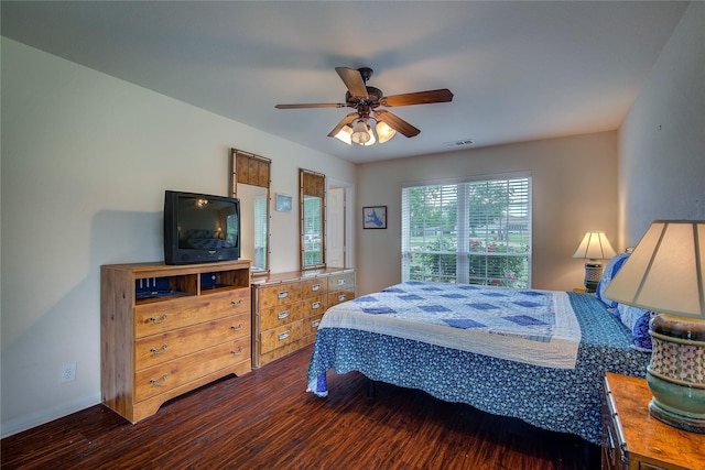 bedroom featuring visible vents, a ceiling fan, baseboards, and dark wood-style floors