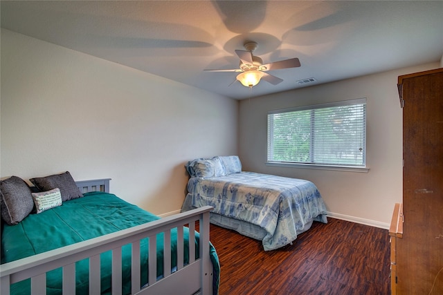 bedroom featuring baseboards, a ceiling fan, wood finished floors, and visible vents