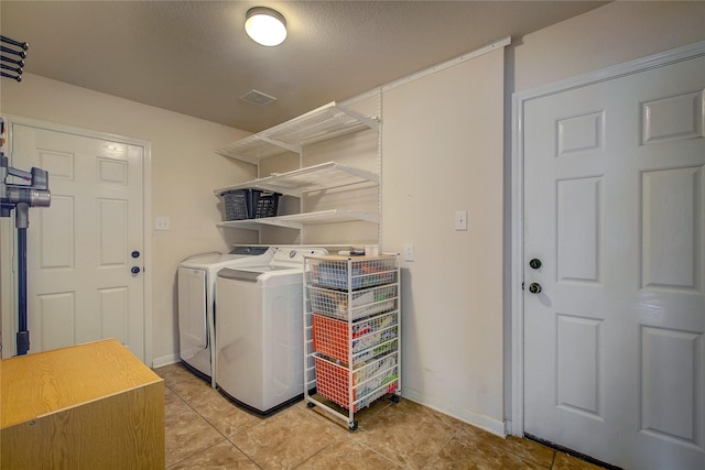 washroom with independent washer and dryer, laundry area, baseboards, and light tile patterned floors