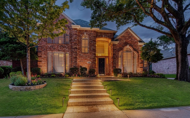 traditional-style house with brick siding and a front yard
