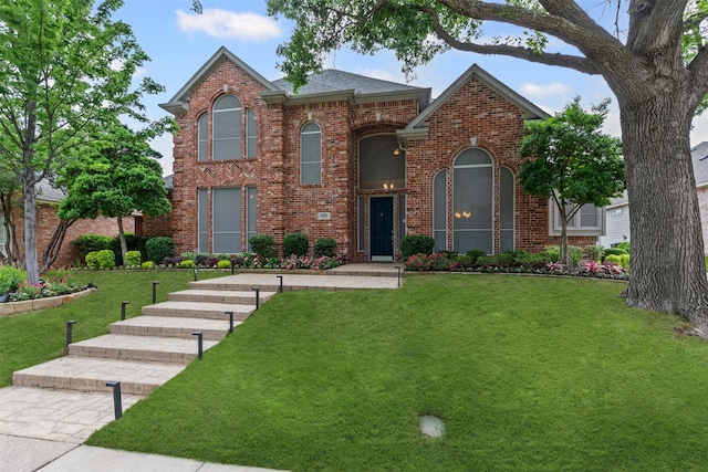 traditional home featuring a front lawn and brick siding