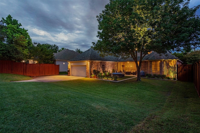 view of yard featuring concrete driveway, an attached garage, and fence