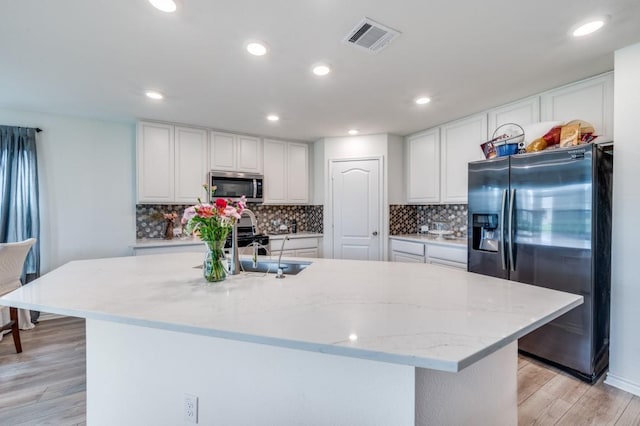 1016 Webb Ave, Aubrey, TX 76227 - kitchen with visible vents, white cabinets, a sink, backsplash, and stainless steel appliances
