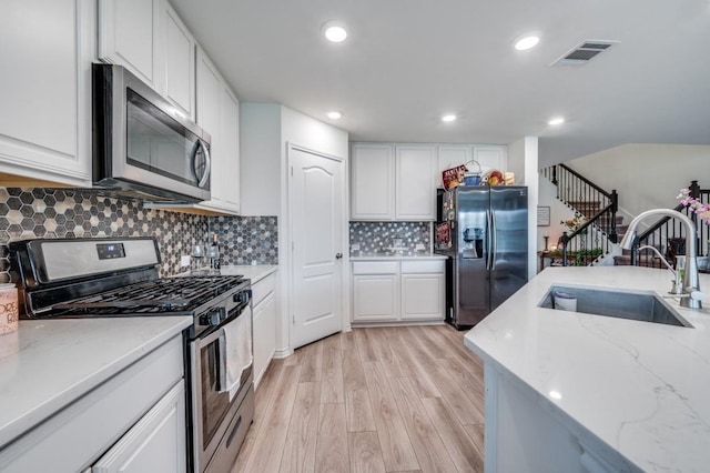 1016 Webb Ave, Aubrey, TX 76227 - kitchen featuring visible vents, light wood-type flooring, a sink, stainless steel appliances, and white cabinetry