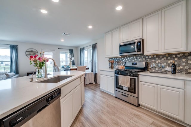 1016 Webb Ave, Aubrey, TX 76227 - kitchen featuring visible vents, a sink, appliances with stainless steel finishes, and tasteful backsplash