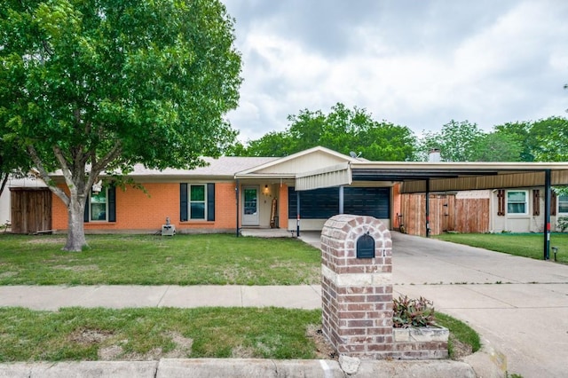 view of front facade with an attached garage, concrete driveway, a front yard, and a carport