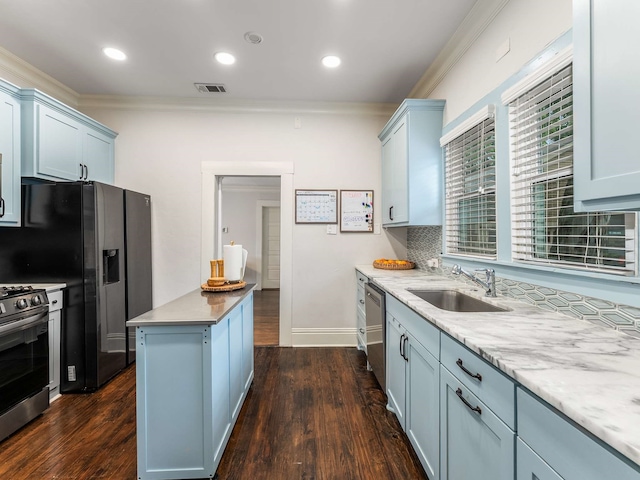 kitchen with crown molding, dark wood-style flooring, appliances with stainless steel finishes, and a sink
