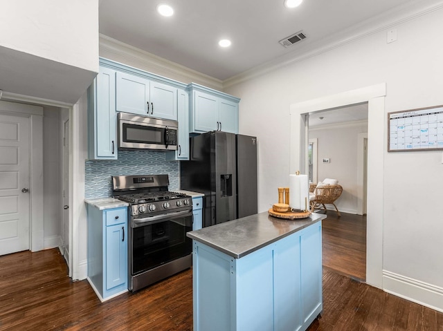 kitchen with stainless steel appliances, dark wood-type flooring, backsplash, visible vents, and ornamental molding