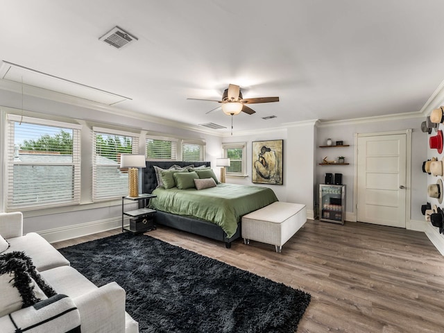 bedroom featuring ornamental molding, attic access, wood finished floors, and visible vents