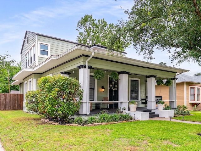 view of front of home featuring a porch, a front lawn, and fence