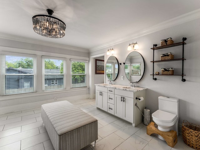 bathroom with a sink, double vanity, toilet, a chandelier, and ornamental molding