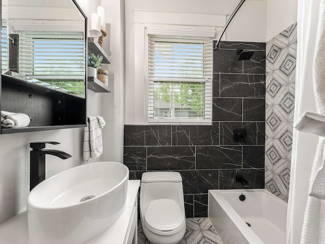 full bathroom with shower / tub combination, a sink, a healthy amount of sunlight, and tile walls