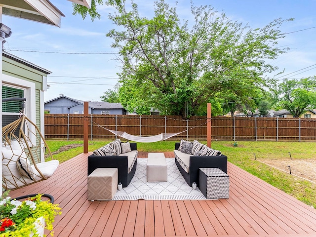 wooden terrace featuring an outdoor living space, a fenced backyard, and a yard