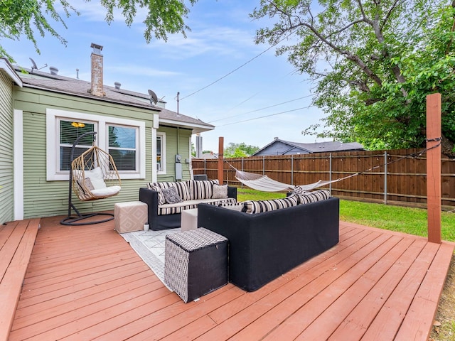 wooden deck with outdoor lounge area and a fenced backyard